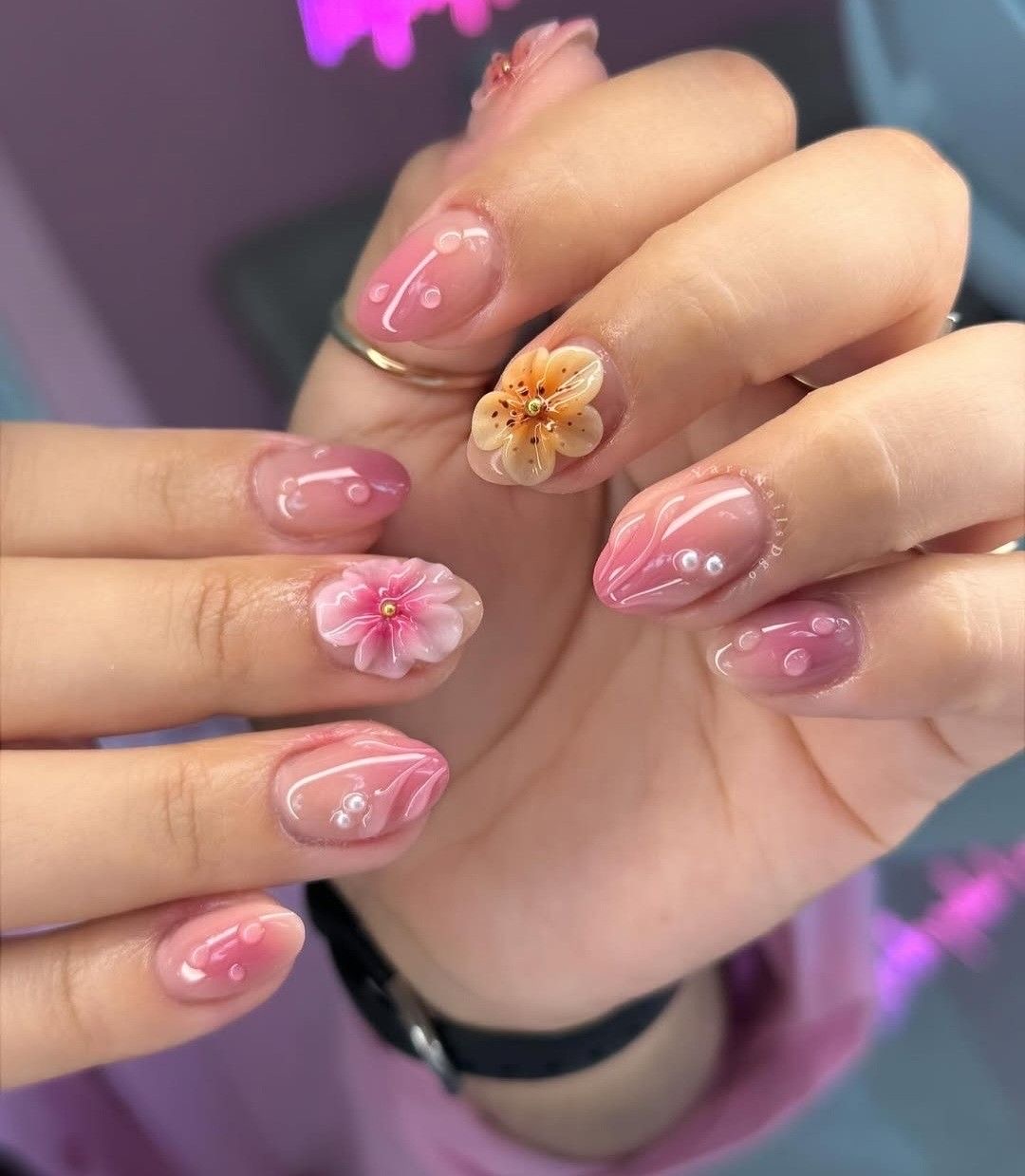 Uñas rosas con flores en relieve
